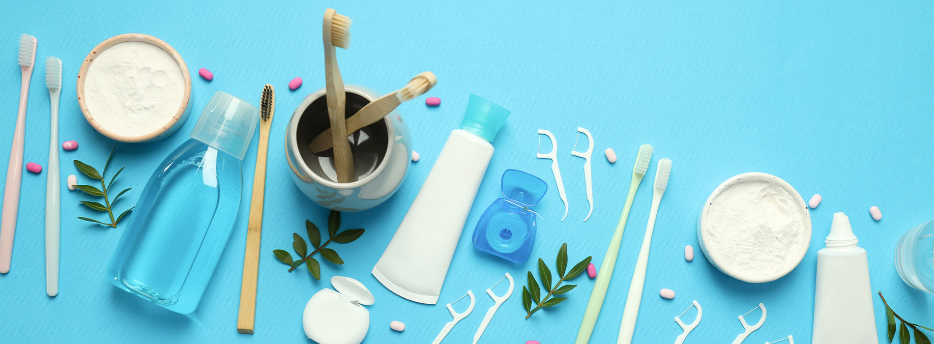 The image shows a collection of cosmetic products on a blue surface, with various items such as bottles, toothbrushes, and cups arranged neatly.
