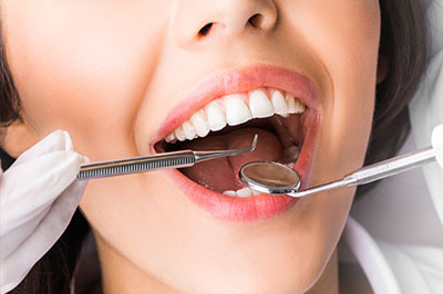 An advertisement featuring a woman with a dental implant being fitted by a dentist, emphasizing cosmetic dental services.