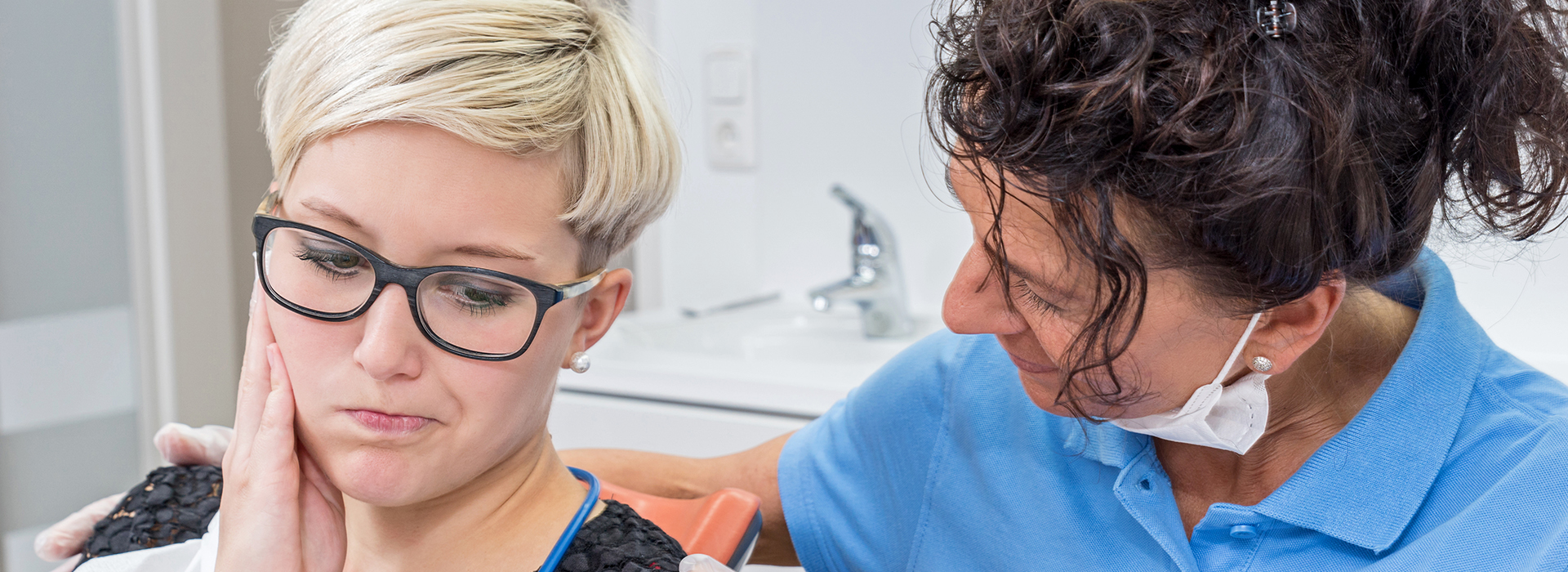 A dentist examining a patient s mouth with a mirror.