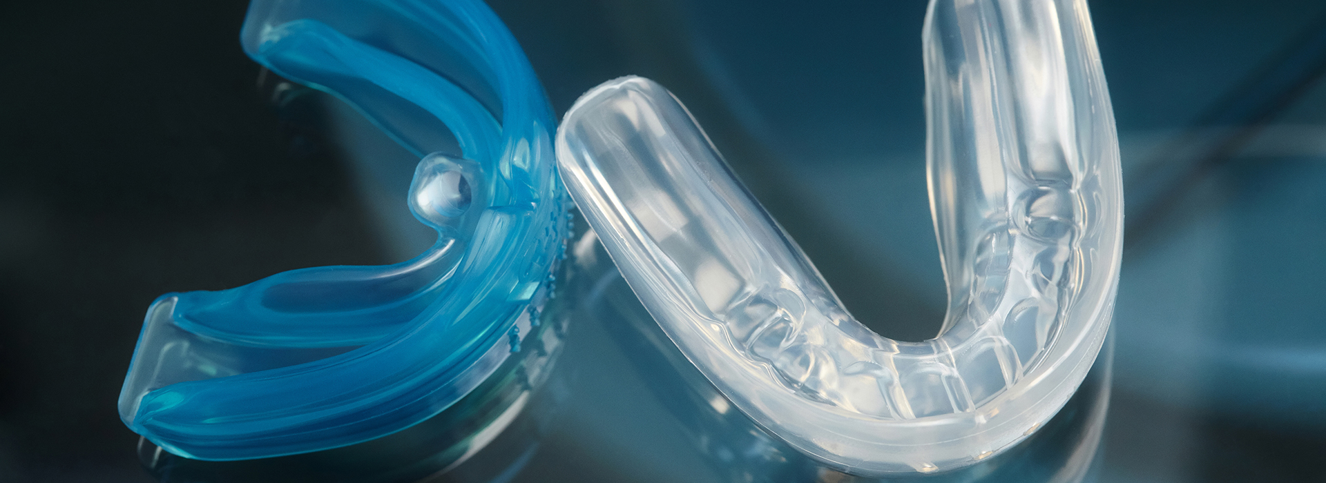 Clear plastic dental braces with a blue elastic band.